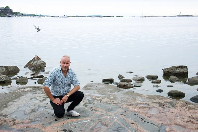 Petri Laaksonen Helsingin Kaivopuiston rantakalliolla. Taustalla näkyy Suomenlinnaa.