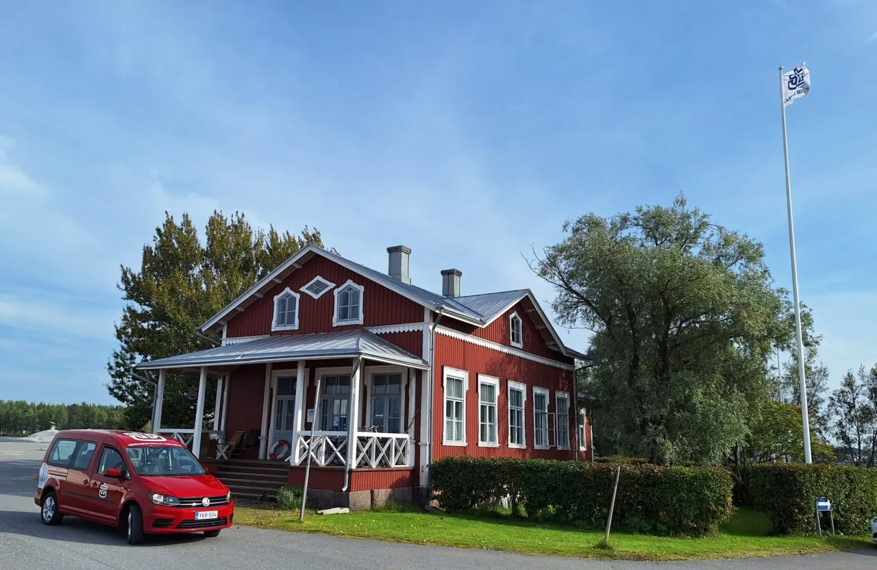 Kokkolan merimieskirkko kantasatamassa. Edessä kirkon punainen auto.
