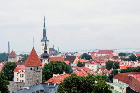 Tallinnan kaupunkia ylhäältä päin, punatiilikattoja ja korkea kirkontorni.