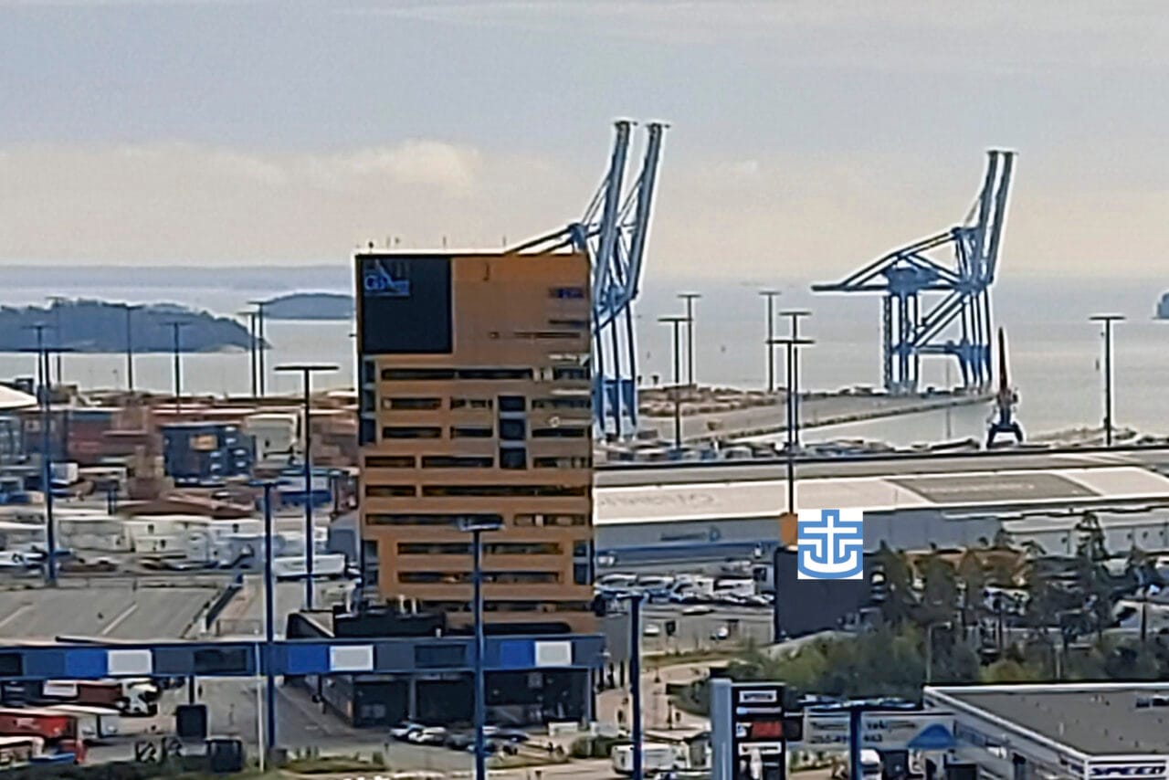 Kuva ylhäältäpäin kohti satamaa ja merta. Keskellä korkea ruskea rakennus.